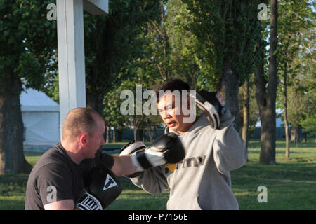 Sgt. 1. Klasse Joel Vallete, Signal Section Chief der Konzernzentrale, 1st Battalion, 14th Infantry Regiment, 3. gepanzerte Brigade Combat Team, 4 Infanterie Division, führt Boxing mitt Bohrer mit einer seiner Auszubildenden am 11. Mai 2017 an Mihail Koglanicenau Air Base, Rumänien. Vallete, eine Armee Boxtrainer, verwendet das Boxen als konstruktiver Weise, freie Zeit mit seiner Kameraden zu verbringen, während auf den Einsatz in Rumänien, sowie die gemeinsame Nutzung einer Leidenschaft seiner mit Anderen. Stockfoto