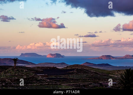 Blaue Stunde erhöhten malerische Landschaft von Lanzarote, hohe Blick auf die anderen Kanarischen Inseln, Spanien, nach Sonnenuntergang mit ausdrucksstarken Himmel voll mit schönen rosa Wolken über dem Atlantik Stockfoto