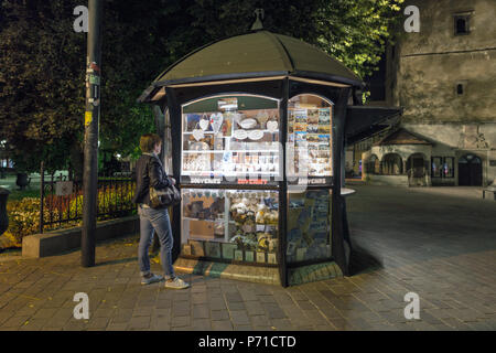 KOSICE, SLOWAKEI - Oktober 02, 2017: Frau steht vor dem Kiosk mit Souvenirs in der Altstadt in der Nacht. Kosice ist die größte Stadt im östlichen Slovaki Stockfoto