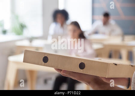 In der Nähe der Pizza Delivery zu Multirassischen Mitarbeiter im Büro. Stockfoto