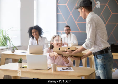 Lieferung Mann, pizza Karton an zufriedene Mitarbeiter Stockfoto