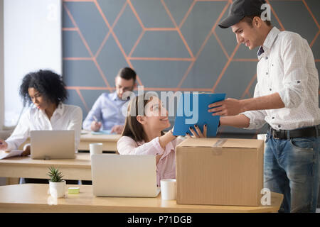 Deliveryman fragt Frau Dokumente unterschreiben nach Paket Lieferung i Stockfoto