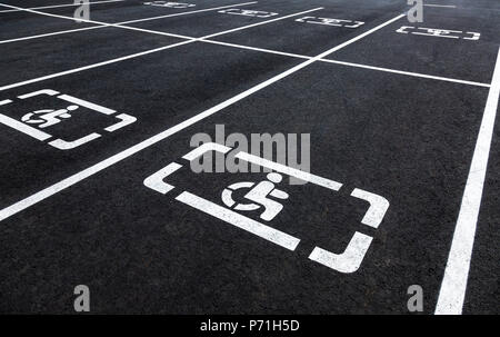Parkplätze mit Rollstuhl Symbol und Markierungslinien auf Asphalt Stockfoto