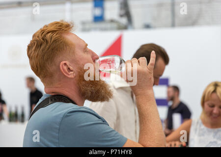 Kiew, Ukraine - Juni 02, 2018: Die junge rothaarige Mann schmeckt Weißwein in Kiew Weinfest. 77 Winzer aus der ganzen Welt nahmen an der großen f Stockfoto