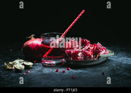 Granatapfel selbst gepresster Saft in ein Glas mit roten Stroh Stockfoto