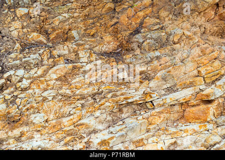 Stein Textur. Felsformation mit Risse und Unebenheiten. Berg der Burg San Juan. Spanisch Beach Resort im Sommer Blanes, Costa Brava, Catalo Stockfoto