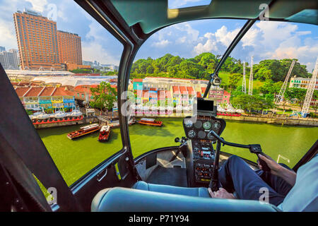 Helicopter Cockpit am Clarke Quay und Riverside in Singapur fliegen. Rundflug über waterfront Skyline mit Bootsfahrt auf dem Singapore River an einem sonnigen Tag. Stockfoto