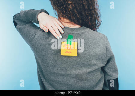 Rückansicht der Frau mit Hinweis auf Klebeband mit April Fools Day Schriftzug auf der Rückseite, April Fools Day Konzept Stockfoto