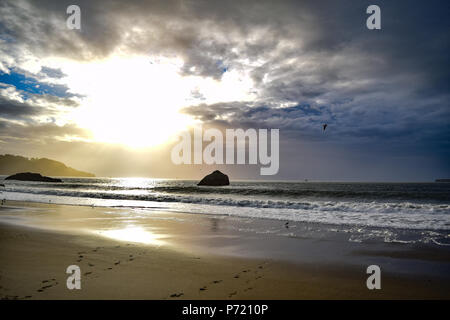 Die Sonne in einer Flamme von Orange und Gelb auf eine völlig einsame Strecke von Marshall's Beach nur wenige Minuten von der Innenstadt von San Francisco, CA Stockfoto