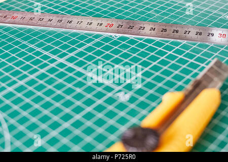 Cutter und ruller und grünen Schneidematte Hintergrund Stockfoto