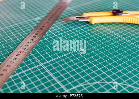 Cutter und ruller und grünen Schneidematte Hintergrund Stockfoto