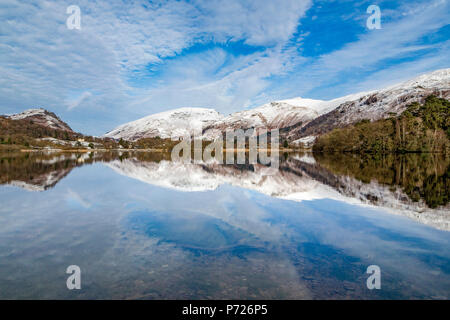 Reflexion der schneebedeckten Berge und dramatischen Himmel im Wasser von Grasmere, Lake District Nationalpark, UNESCO, Cumbria, England, Großbritannien Stockfoto