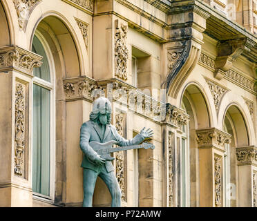 Statue von George Harrison spielt eine Gitarre ausserhalb der Tag Nacht Hotel,John Street, Liverpool, England, UK Stockfoto