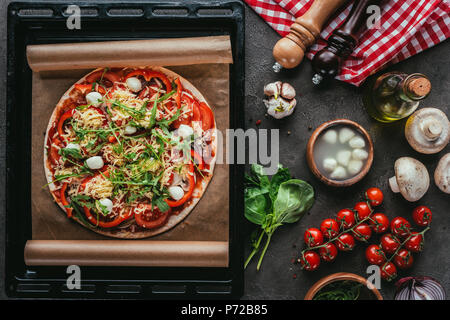 Blick von oben auf die frisch gebackene Pizza mit Zutaten aus Beton Tabelle Stockfoto