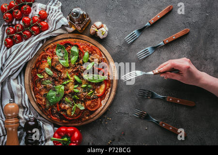 7/8 Schoß der Frau unter Stück leckere Pizza mit Gabel Stockfoto