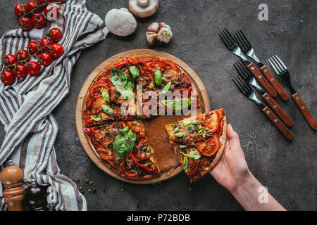 7/8 Schoß der Frau unter Stück frisch gebackene Pizza Stockfoto