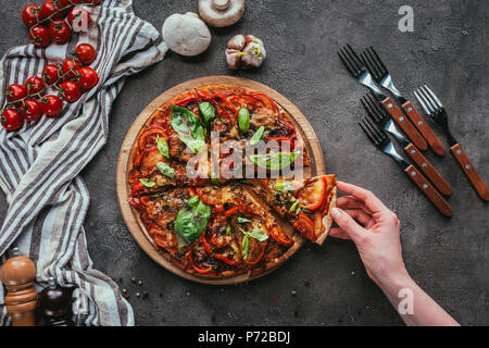 7/8 Schoß der Frau unter Stück Pizza Stockfoto