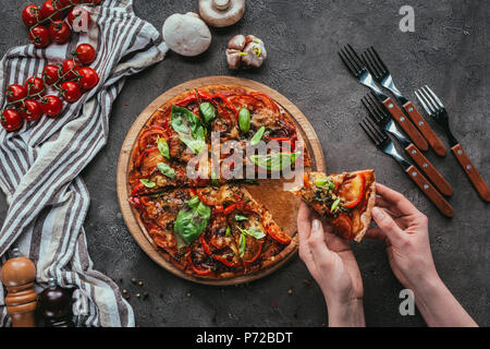 7/8 Schoß der Frau unter Stück frisch gebackene Pizza Stockfoto