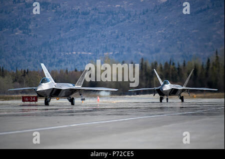 Zwei U.S. Air Force F-22 Raptors, auf die 3 Flügel, Taxi vor dem Abheben von der gemeinsamen Basis Elmendorf-Richardson, Alaska zugewiesen, während der Übung nördlichen Rand 2017, 11. Mai 2017. Mit den Teilnehmern und Vermögenswerte aus der US-Luftwaffe, Heer, Marine Corps, Navy und der Coast Guard, nördlichen Rand ist Premier Alaska's joint-Training darauf ausgerichtet, den Betrieb zu üben und die Interoperabilität zwischen den Diensten zu verbessern. Stockfoto