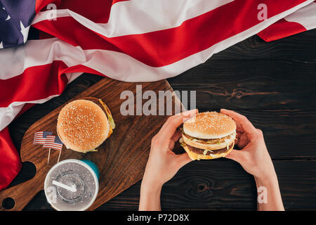 Teilweise mit Blick auf die Frau mit Burger, Präsidenten Day Feier Konzept Stockfoto