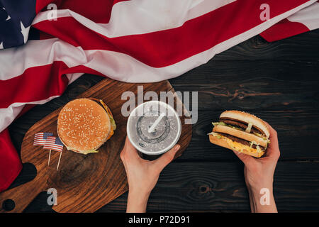 Teilweise mit Blick auf die Frau mit Burger und Soda drink, Präsidenten Day Feier Konzept Stockfoto