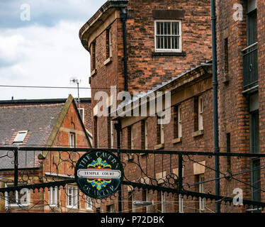 Overhead schmiedearbeiten Temple Court street sign, Cavern Quarter mit roten Backsteinbauten, Liverpool, England, UK Stockfoto