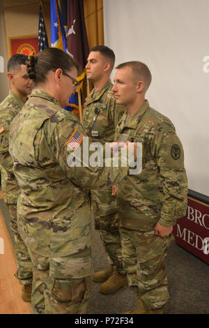 Armee Oberst Margaret Nava, Chief nursing Officer, präsentiert Sgt. Matthew Reynolds und SPC. Tyler Rumpf, ihr Silber Abzeichen als Teil des 68W-Nutzung 11. Mai während der Krankenschwestern Woche Feier in der Brooke Army Medical Center Auditorium. Das silberne Abzeichen bedeutet, dass Sie alle ihre Kompetenzen innerhalb eines Patienten Einstellung erreicht ist. Stockfoto