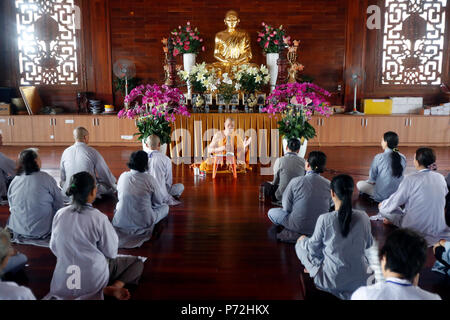Ein Lehrer beauftragt eine Gruppe von Menschen, wie buddhistische Gesänge rezitieren, Minh Dang Quang buddhistischen Tempel, Ho Chi Minh City, Vietnam, Indochina, Asien Stockfoto