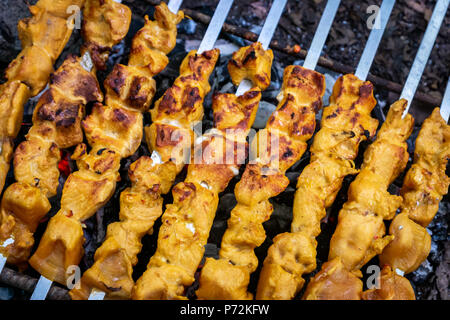 Gegrilltes kebab Kochen auf Metall Spieß Nahaufnahme. Gebratenes Fleisch am Grill zubereitet. BBQ frisches Rindfleisch Scheiben schneiden. Traditionelle östliche Gericht Shish Kebab. Stockfoto