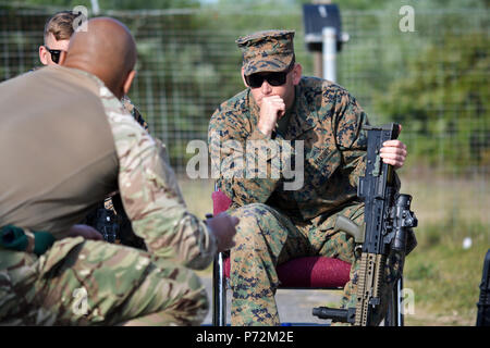 Us Marine Corps Sgt. Victor Netta, Chief primäre Treffsicherheit Instructor, Treffsicherheit, Waffen Training Bataillon, hört sich die Anweisung auf dem SA80A2 L 85 Sturmgewehr von Royal Marine Cpl. Chris Bounvou-Nikolov, Bekämpfung Treffsicherheit Trainer, Commando Training Center, an altcar Ausbildungslager, Hightown, Vereinigtes Königreich, am 11. Mai 2017. Das US Marine Corps reist in das Vereinigte Königreich, die jährlich in den Royal Marines operative Schießen Wettbewerb bestehen zu können und lernen, mit ihren Verbündeten beim Aufbau von Beziehungen. Stockfoto