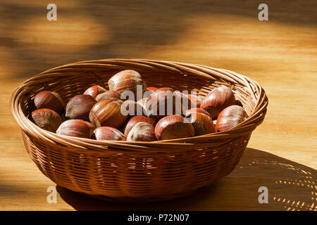 Haselnüsse in einem Korb auf einem Holztisch Stockfoto