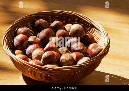 Haselnüsse in einem Korb auf einem Holztisch Stockfoto