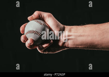 7/8 shot der männlichen Hand baseball ball isoliert auf Schwarz Stockfoto