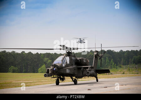 Eine AH-64D Apache Helikopter Rollen in den Parkplatz bei Ech Stagefield, Fort Rucker, Ala Mai 22, 2013 Als zweite Flugzeug führt eine abschließende Vorgehen während der "Tasche" Teil der Apache Helikopter. In der Phase der Ausbildung, Cockpit windows Student sind vollständig abgedeckt. Das Ziel ist es, den Student Pilot das Flugzeug allein durch Bezug auf das AH 64 HMD zu fliegen, auch bekannt als der Integrierten Helm und Anzeige Sichtung System (Ihadss) Kraft. Die ihadss bietet eine Monokular Anzeige der außerhalb des Flugzeugs über Fernsehen oder thermischen sensor auf der Nase des Flugzeugs. Stockfoto