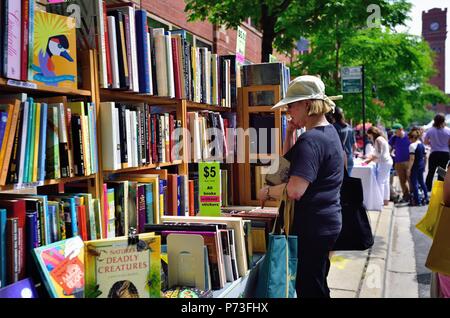 Chicago, Illinois, USA. Frau denkt über einen möglichen Kauf bei der jährlichen Drucker Reihe beleuchtet Fest (ehemals Drucker Reihe Book Fair). Stockfoto