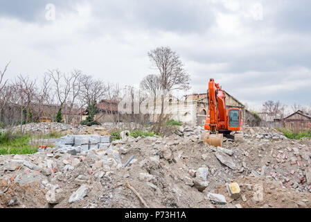 Ansicht der Abriss eines alten Gebäudes mit Bagger Bagger für den Bau neuer Gebäude. Stockfoto