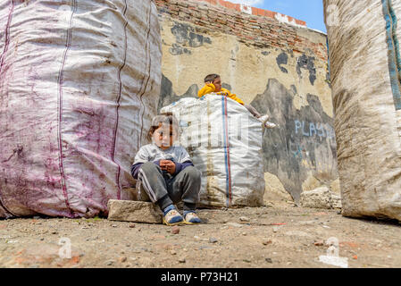 Nicht identifizierte Kindern sitzt in der Nähe von Müll gesammelt Säcke in Istanbul, Türkei, 09. April 2017 Stockfoto