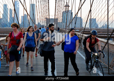 Fußgänger und Radfahrer vermeiden Konflikte auf dem Fußgängerweg der Brooklyn Bridge über den East River in New York, NY. Stockfoto