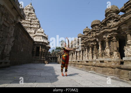 Bharatha natyam, eine der acht klassischen Tanzformen Indiens, wird aus dem Bundesstaat Tamil Nadu. Tänzerin wirft vor dem Tempel mit Skulpturen Stockfoto