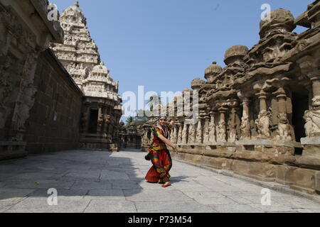 Bharatha natyam, eine der acht klassischen Tanzformen Indiens, wird aus dem Bundesstaat Tamil Nadu. Tänzerin wirft vor dem Tempel mit Skulpturen Stockfoto