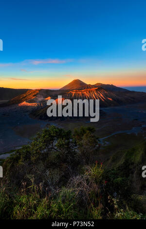 Sonnenaufgang am Mount Bromo Vulkan, Ostjava, Indonesien. Sonnenlicht beleuchtet nur die Spitzen der vulkanische Krater. Milden Rauch aus Mt. Bromo gesehen werden. Stockfoto