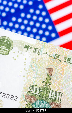 US Flag/Sterne und Streifen mit 1 Yuan Banknote - Metapher US-China trade Krieg/Handelsstreit/Trumpf Stahltarife, Chinesischer Renminbi Yuan Schwäche. Stockfoto