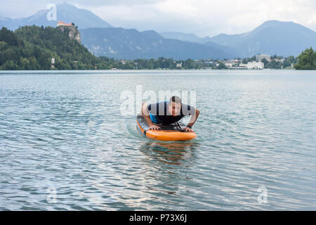 Junger Mann Ausübung auf paddle Board am See Stockfoto