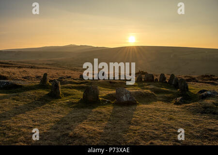 Goldene Licht über antike Granit bekannt als die Neun Dirnen Steinkreis in Dartmoor Stockfoto