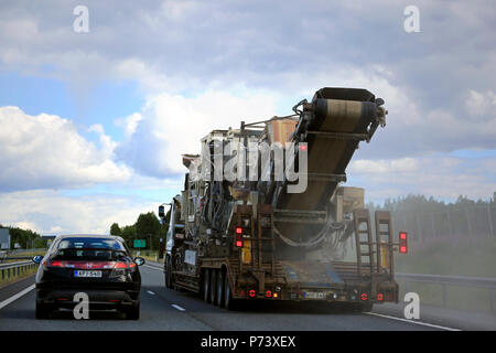 Auto überholt Auflieger Lkw, transportiert einen großen Metso Brecher auf der Autobahn. Ansicht von hinten überholen. Salo, Finnland - 30. Juni 2018. Stockfoto