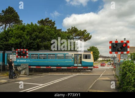 Diesel s-bahn vorbei an einem Bahnübergang, wie es auf den Rhoose Cardiff International Airport Bahnhof in das Tal von Glamorgan, Wales kommt Stockfoto