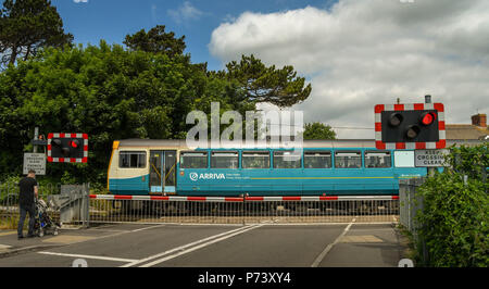 Diesel s-bahn vorbei an einem Bahnübergang, wie es auf den Rhoose Cardiff International Airport Bahnhof in das Tal von Glamorgan, Wales kommt Stockfoto