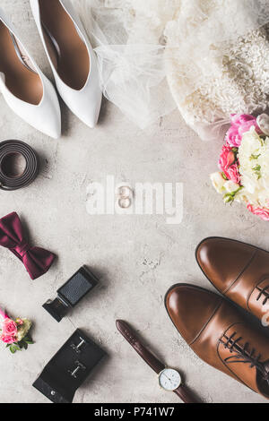 Blick von oben auf die Hochzeit Zubehör und Ringe auf der grauen Tischplatte Stockfoto