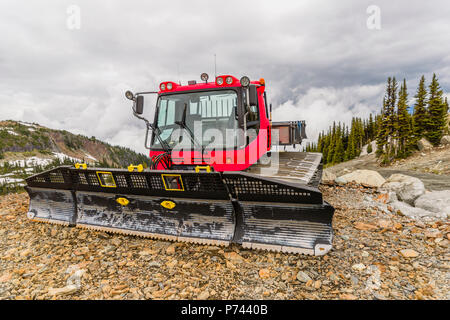 Roter Traktor, schneepflug vor einem Berg auf dem Felsen und Steine im Sommer Tag geparkt Stockfoto