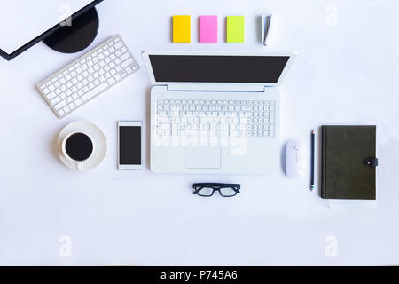 Weiß Schreibtisch im Büro mit Laptops, Smartphones und andere Arbeiten mit einer Tasse Kaffee. Ansicht von oben mit der Kopie Platz für die Eingabe des Textes. Designer Arbeitsbereich Stockfoto